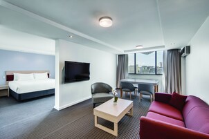 Suite estudio Deluxe, 1 cama de matrimonio grande, no fumadores | Zona de estar | Televisión LCD de 50 pulgadas con canales por cable, una televisión