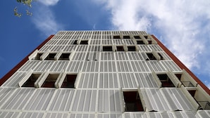 Un edificio alto con fachada de entramado y varios balcones.
