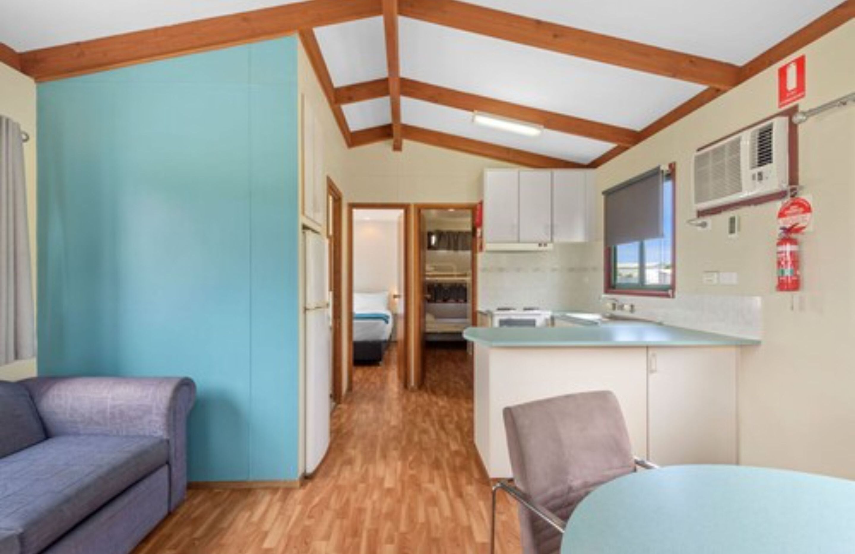 Una habitación compacta con kitchenette, comedor y sofá.