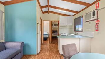 Una habitación compacta con kitchenette, comedor y sofá.