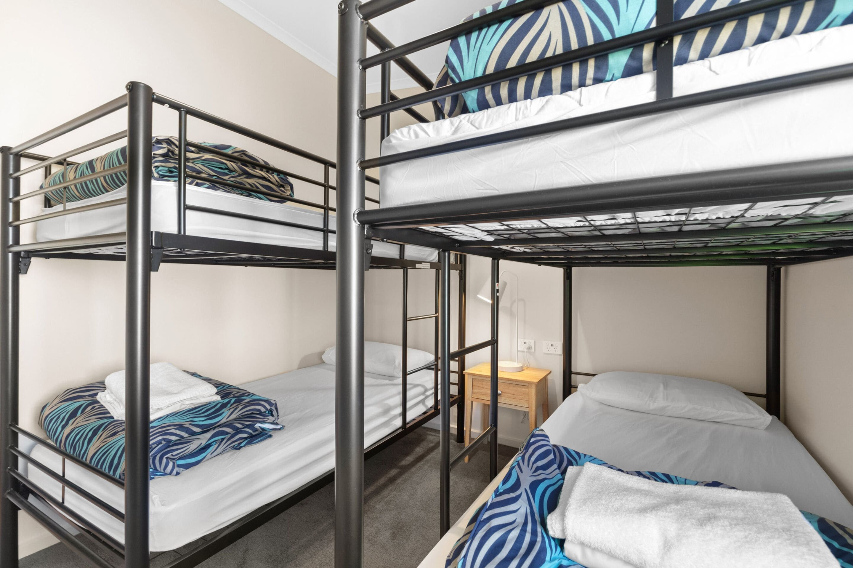 A bunk bed room with a desk and a small table.