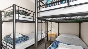 A bunk bed room with a desk and a small table.