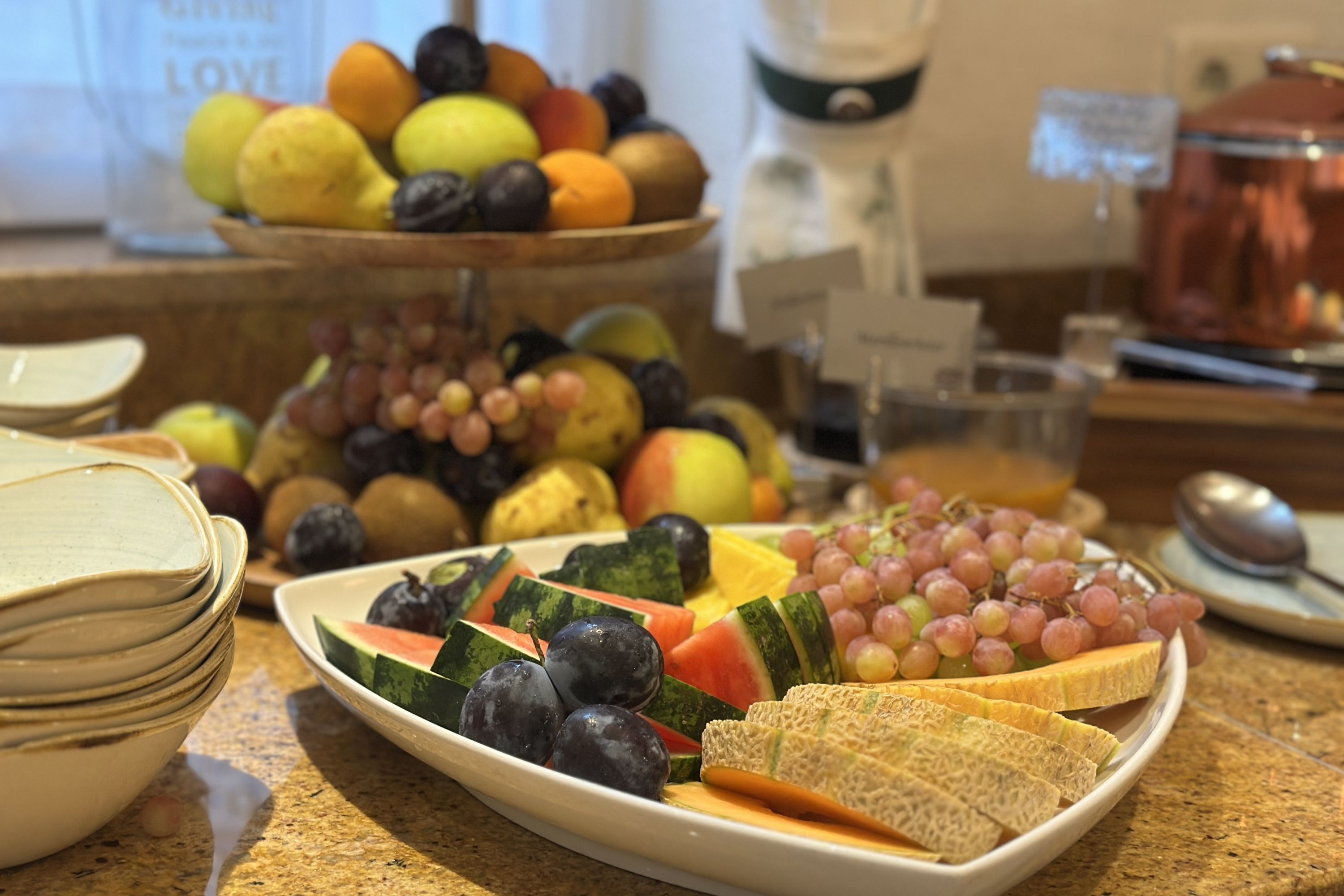 A breakfast buffet with various fruits and sliced bread.
