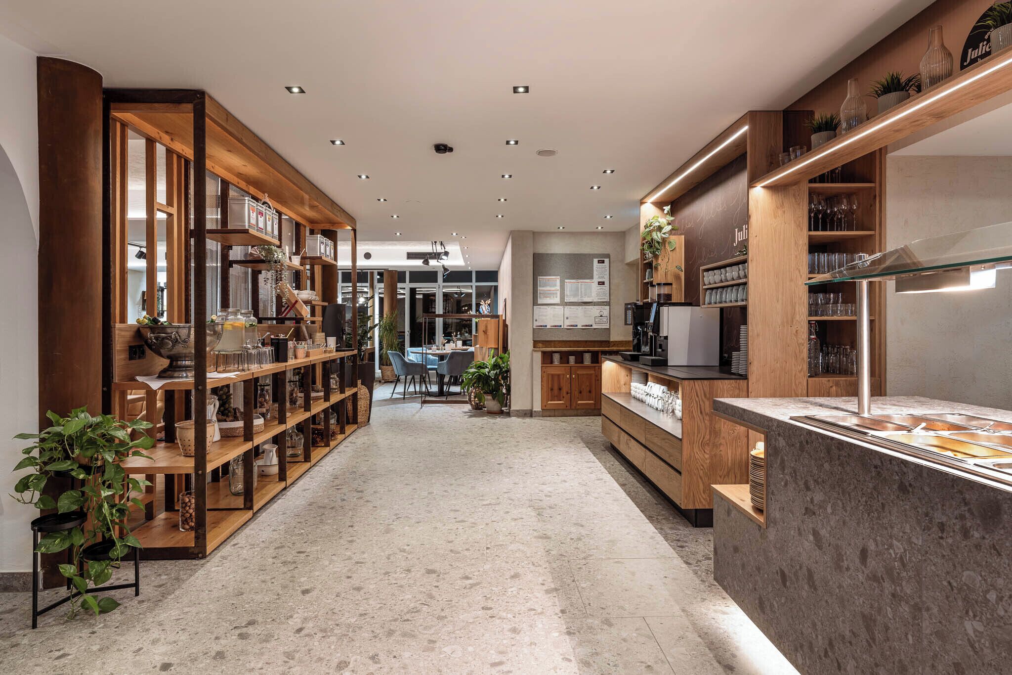 A modern interior with wooden shelving, a kitchen area, and a seating space.