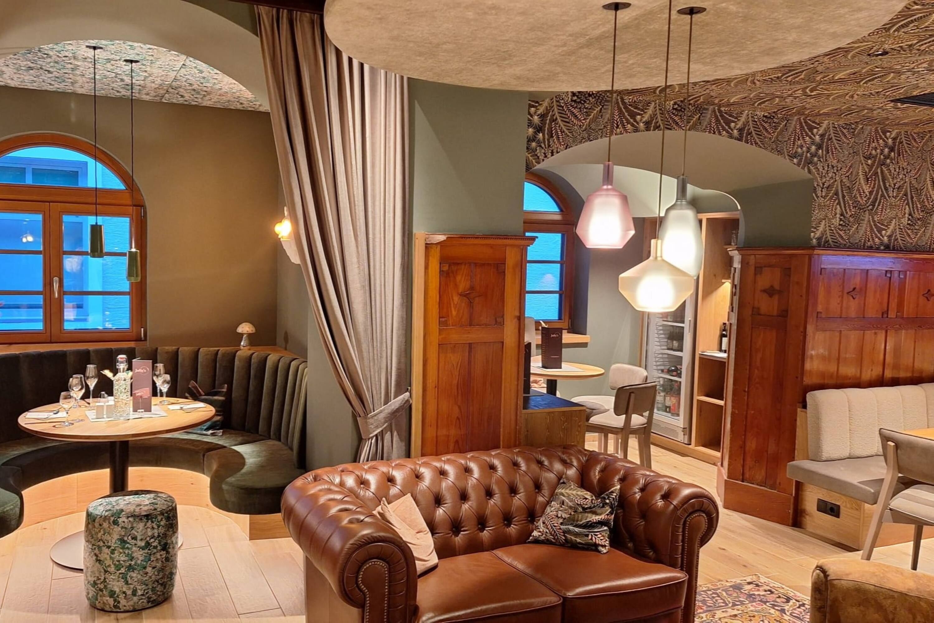 A cozy interior with a leather sofa, round dining table, and wooden cabinets.