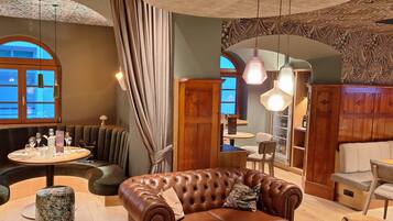 A cozy interior with a leather sofa, round dining table, and wooden cabinets.