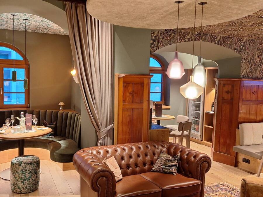 A cozy interior with a leather sofa, round dining table, and wooden cabinets.