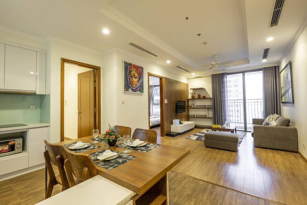 A modern apartment with a dining area, kitchen, living room, and balcony.