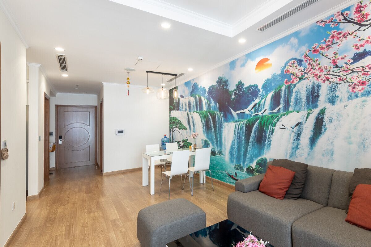Ein modernes Wohnzimmer mit Essbereich, einer Couch und einem Wandgemälde mit einem Wasserfall.