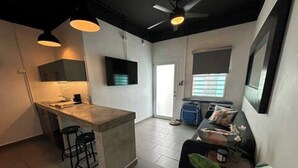 Eine moderne Küche mit Bar, Essbereich inklusive Sofa und Deckenventilator.