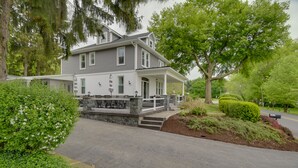 A two-story house with a porch, stone steps, and a driveway. - Waterfront Home w/ Hot Tub in Wrightsville! (Wrightsville)