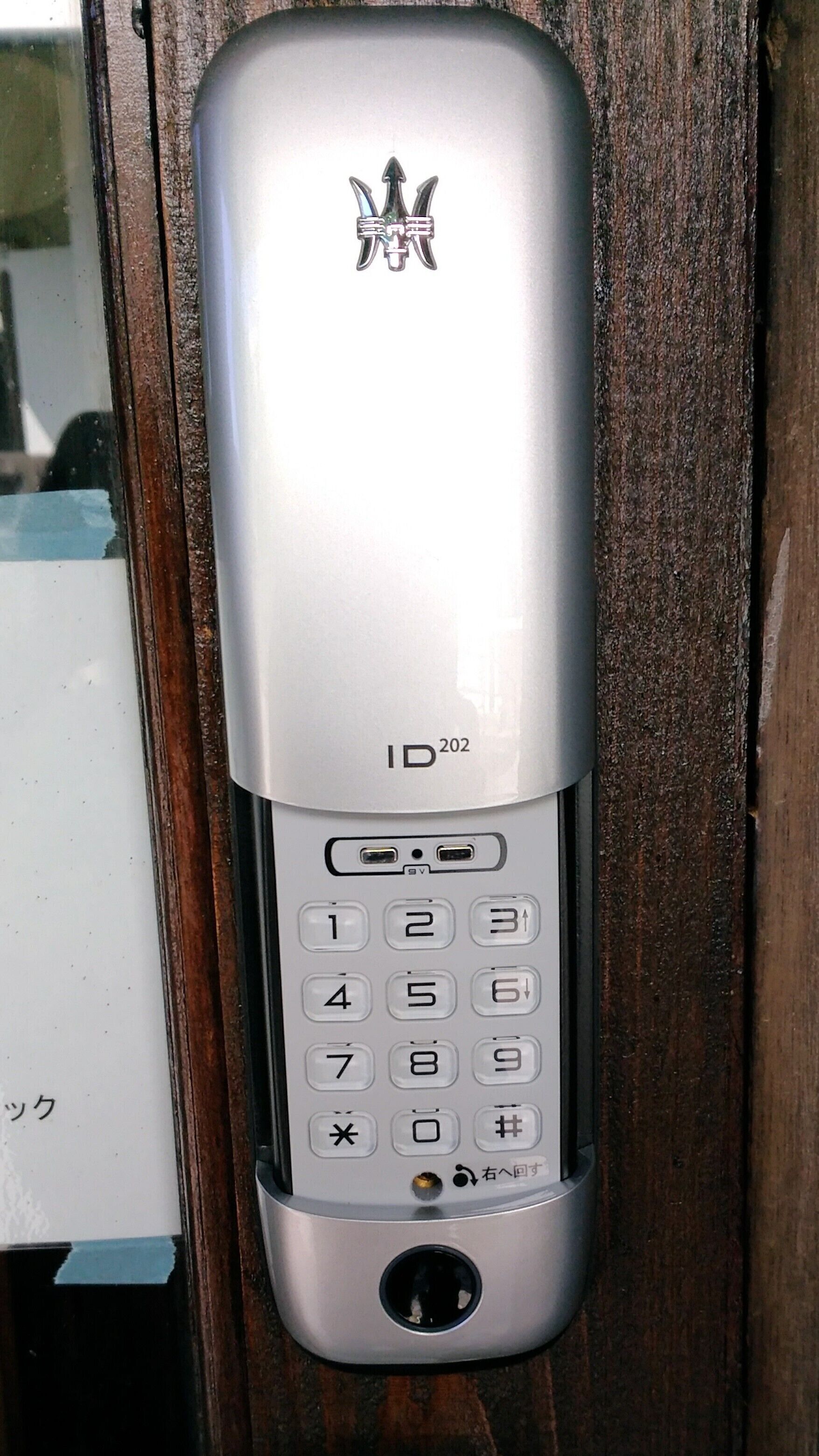 Un portero electrónico ID202 plateado con teclado numérico y rejilla para altavoz.