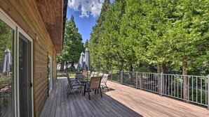 A wooden deck with outdoor furniture and a glass door leading to a room. - Secluded Camp Connell Home w/ Deck + Fireplace! (Camp Connell)