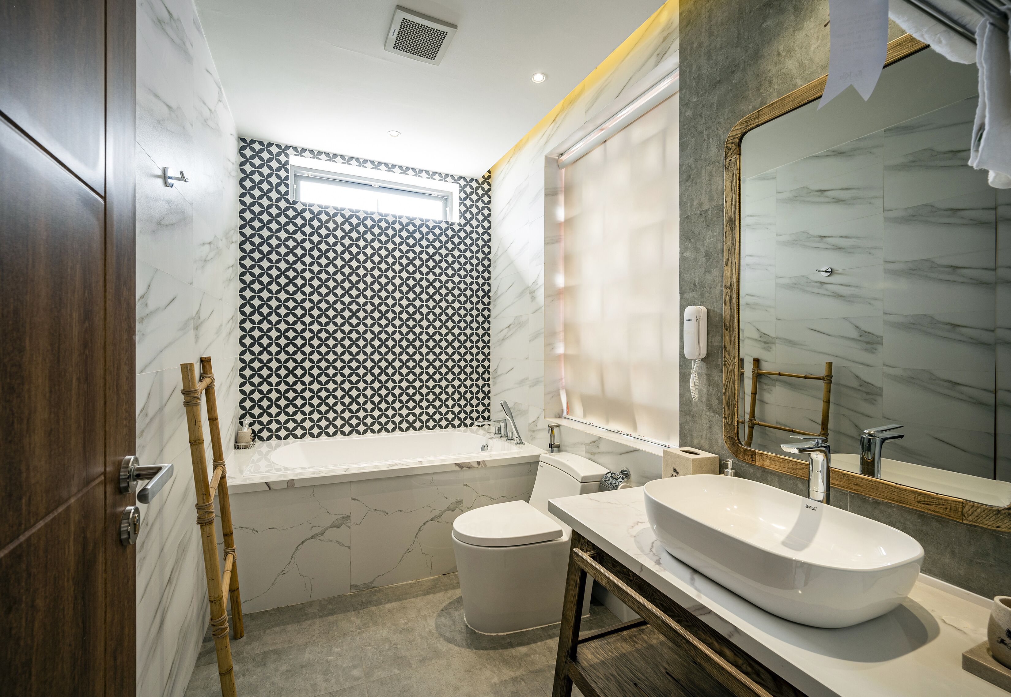 Un baño moderno con una bañera grande, un inodoro y un lavabo con espejo.