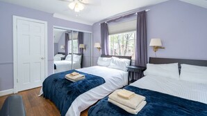 A bedroom with two beds, a ceiling fan, a window with curtains, and a door. - Spacious 4BR CozySuites in Old Town Alexandria (Alexandria)