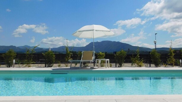 A swimming pool with a clear view of mountains in the background. - Hotel Fortuna B&B (Costermano sul Garda)