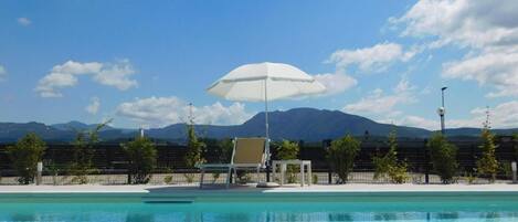 Alberca al aire libre por temporada y sombrillas en la alberca