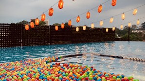 A swimming pool with colorful floating balls and string lights. - Bigland Bogor Hotel Powered by Archipelago (Bogor)