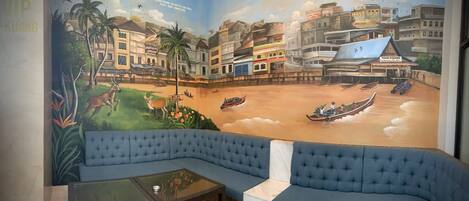 Habitación con un mural que muestra una escena tropical con barcos y edificios.