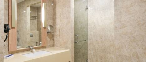 Un bagno moderno con uno specchio grande, un lavandino, una doccia e una vasca da bagno.