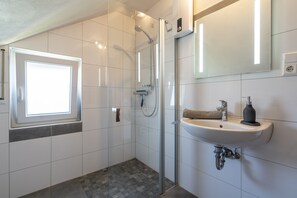 Chuveiro, secador de cabelo, toalhas de banho, sabonete