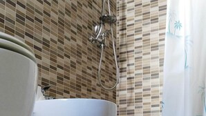 Ein Badezimmer mit einer Badewanne, einer Dusche und einem WC.