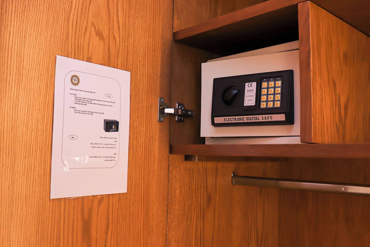 A wooden cabinet with a safe inside. Instructions for using the safe are visible on a piece of paper attached to the cabinet.