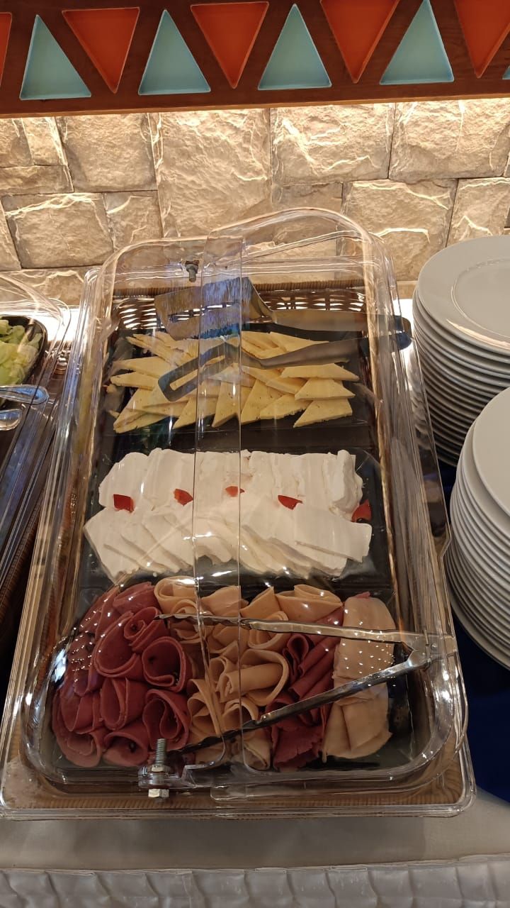 Un bufé con diferentes opciones de comida, incluyendo tortillas, queso y carnes.