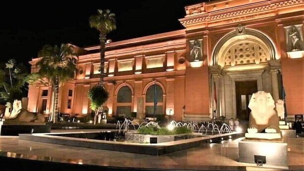 Un edificio amplio y bien iluminado con una entrada imponente, una fuente y palmeras.