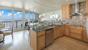 Una cocina moderna con armarios de madera, una campana extractora de acero inoxidable y una isla grande con lavavajillas.