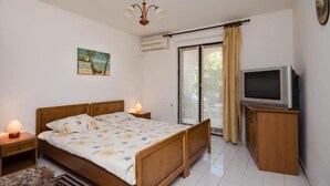 A bedroom with a bed, bedside lamps, a TV, and a painting on the wall. - Apartment 2039/31767 (Istria - Banjole), 300m from the beach (Banjole)