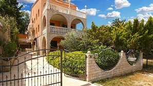 A multi-story building with a balcony, a gated entrance, and surrounding greenery. - Apartment 2039/31774 (Istria - Banjole), 300m from the beach (Banjole)