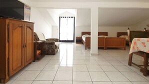 A spacious room with a large wooden cabinet, a floral sofa, two wooden beds, and a television on a stand. - Apartment 2039/31774 (Istria - Banjole), 300m from the beach (Banjole)