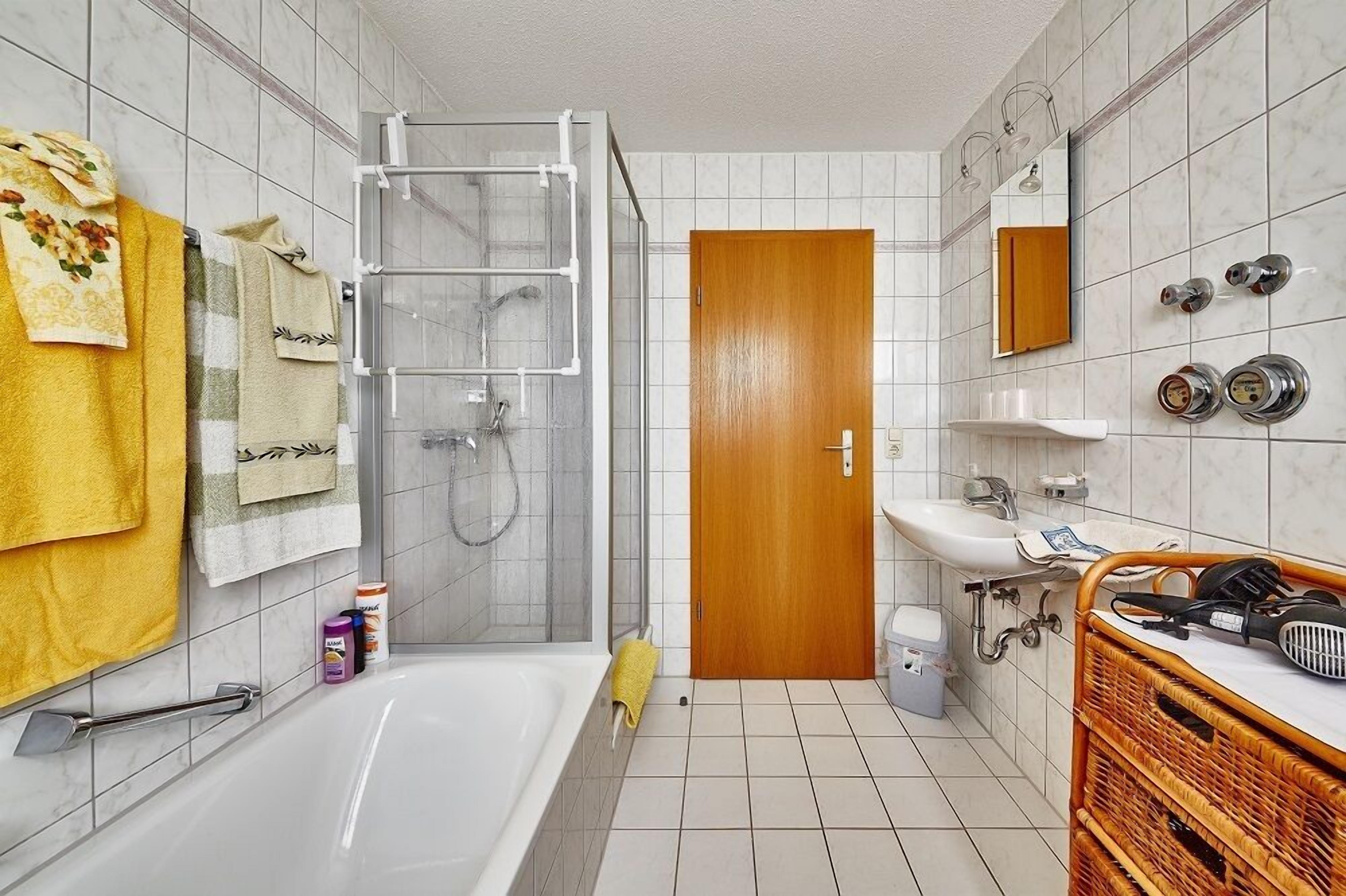 A bathroom with a bathtub, shower, and sink.
