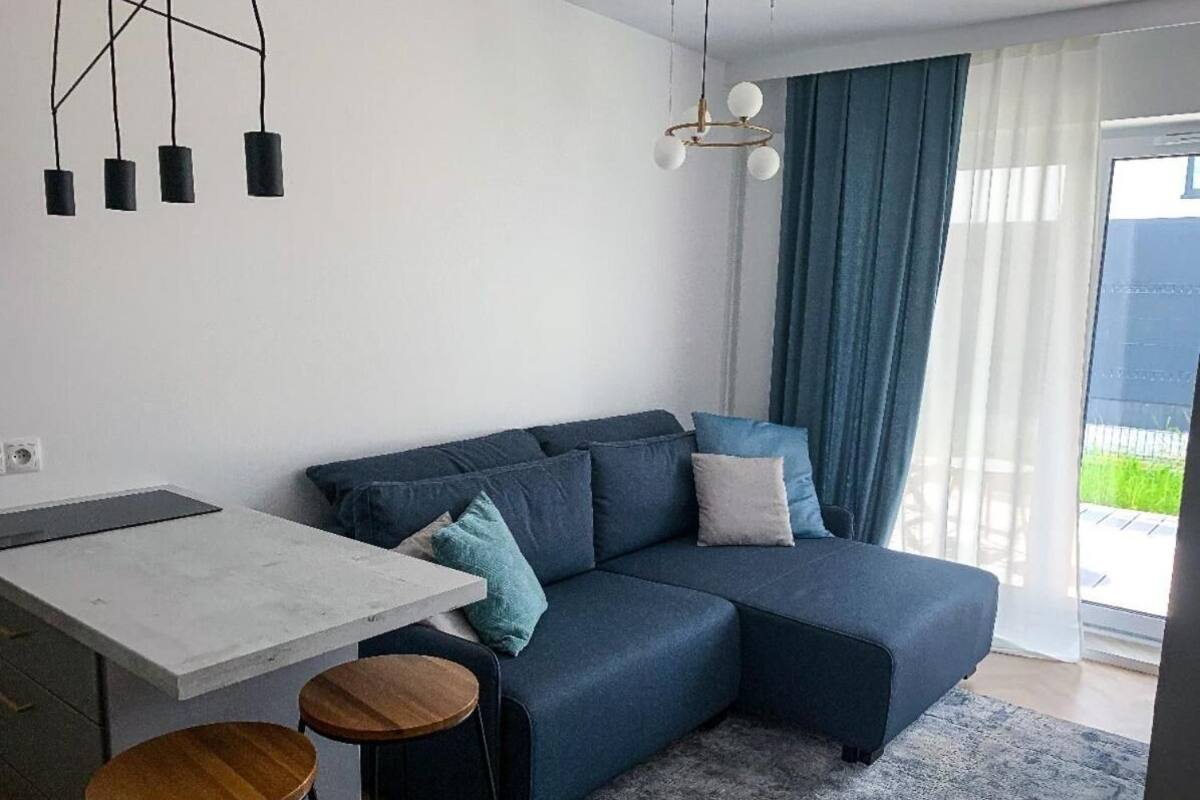 Un salon moderne avec un canapé, une table à manger et deux tabourets.