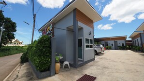 A modern building with a flat roof, a small entrance, and a signboard. - OYO 1121 Phuree Resort (Sattahip)