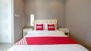 A modern hotel room with a large bed, two nightstands, a mirror, and a red throw blanket. - OYO 1121 Phuree Resort (Sattahip)