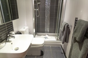 Apartamento executivo | Banheiro | Chuveiro, produtos de toalete grátis, secador de cabelo, chinelos