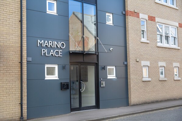 A building with a sign reading "MARINO PLACE" and a glass door entrance. - Citystay Living - Marino Place (Cambridge)