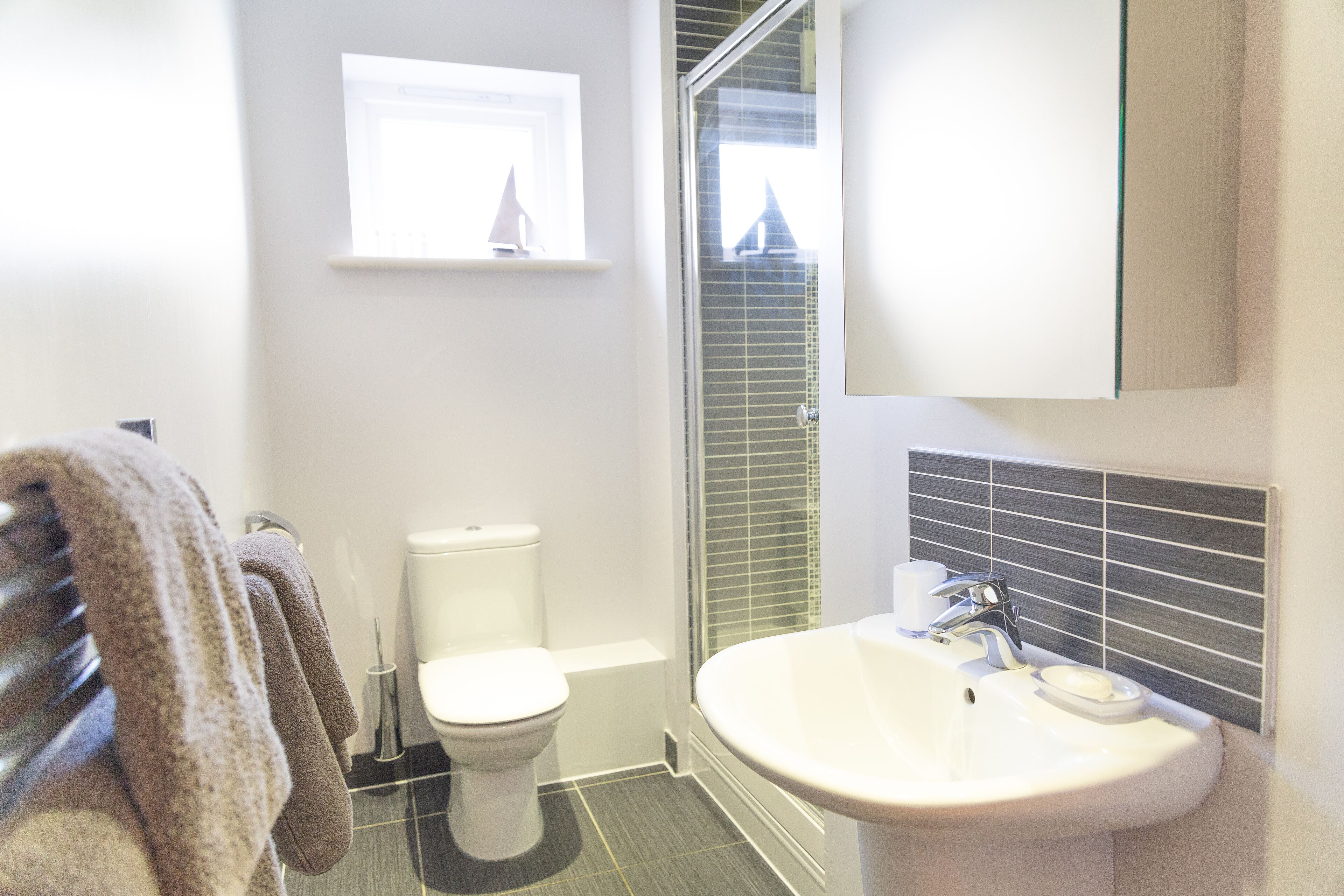 A bathroom with a toilet, sink, and towel rack.