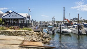 A marina with boats docked, a stone wall, and a building labeled "8 Knots Tavern". - Beautifully renovated studio apartment in Fremantle (Fremantle)
