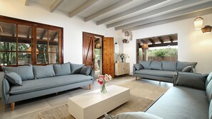 Un soggiorno moderno con due divani grigi, un tavolino bianco e una porta in legno.