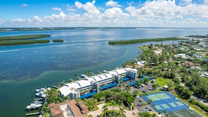 Een kusthotel met meerdere gebouwen, een jachthaven en tennisbanen.