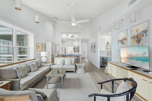 A spacious living area with a sofa, coffee table, and a television.