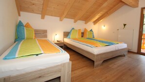 Un dormitorio con dos camas, vigas de madera en el techo y un radiador en la pared.