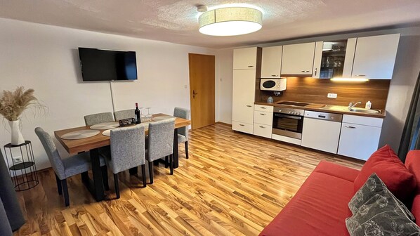 Un appartement moderne comprenant un coin repas, une cuisine et un espace de vie.