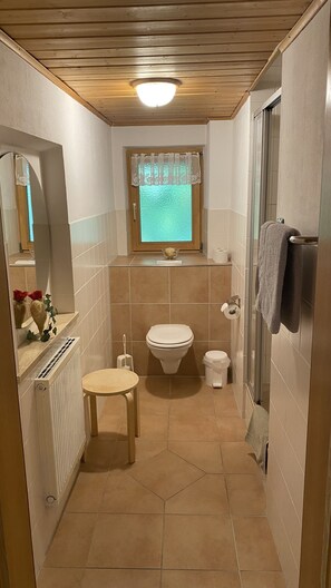 Une petite salle de bain comprenant des toilettes, un bidet et une petite table.