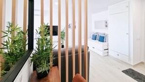 A modern living room with a sofa, a coffee table, and two potted plants. - Apartment Praia Rocha Vista Mar Summer 1 (Portimão)