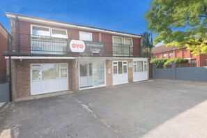 A two-story building with a sign for 'OYO Honeycroft Lodge'.