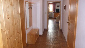 A hallway with wooden doors, a bench, and a mirror. - Vacation apartment no. 14 for 2 - 4 persons, approx. 100 m², 1 bedroom, living room, kitchen, bathroom (Bischofswiesen)